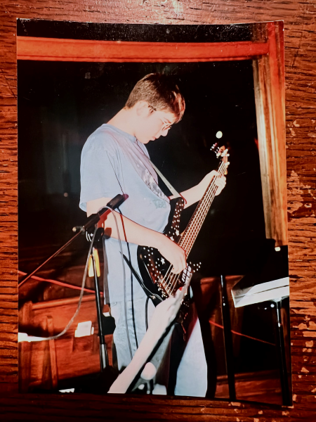Photo of a photo of Phil C-B as a teenager playing the bass